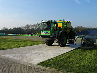Large machine with long sprayer beams standing on a test floor