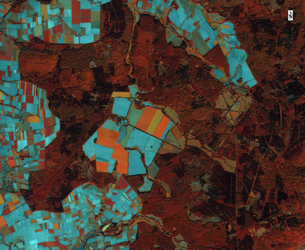 Infrared image: vegetation is displayed in various shades of red, e.g. dark red for coniferous forest, light red for deciduous forest, orange areas for sugar beet and catch fruit, blue for soil after tilling