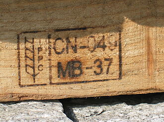 Close-up of a wooden pallet branded with a seal