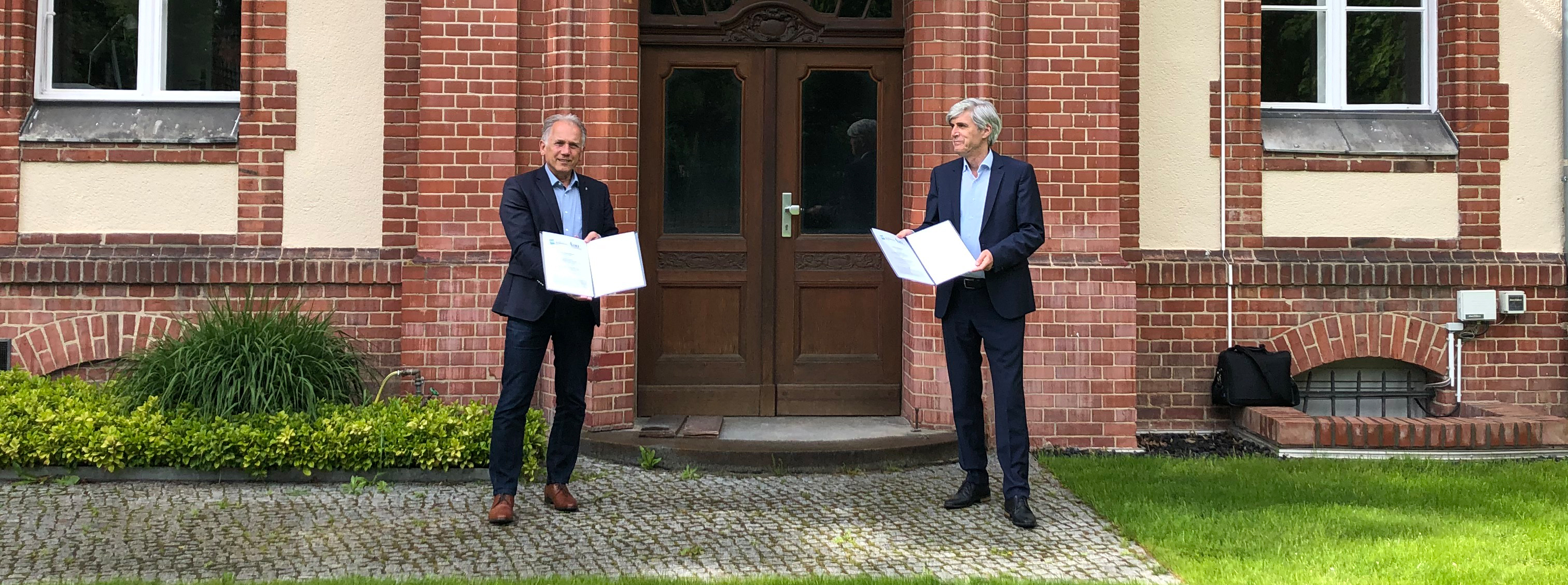 Der Leiter des ZALF Prof. Dr. Frank Ewert (r.) und der Präsident des JKI Prof. Dr. Frank Ordon präsentieren die unterzeichneten Kooperationsverträge vor dem JKI-Eingang in Berlin -Dahlem. © H.Beer/JKI