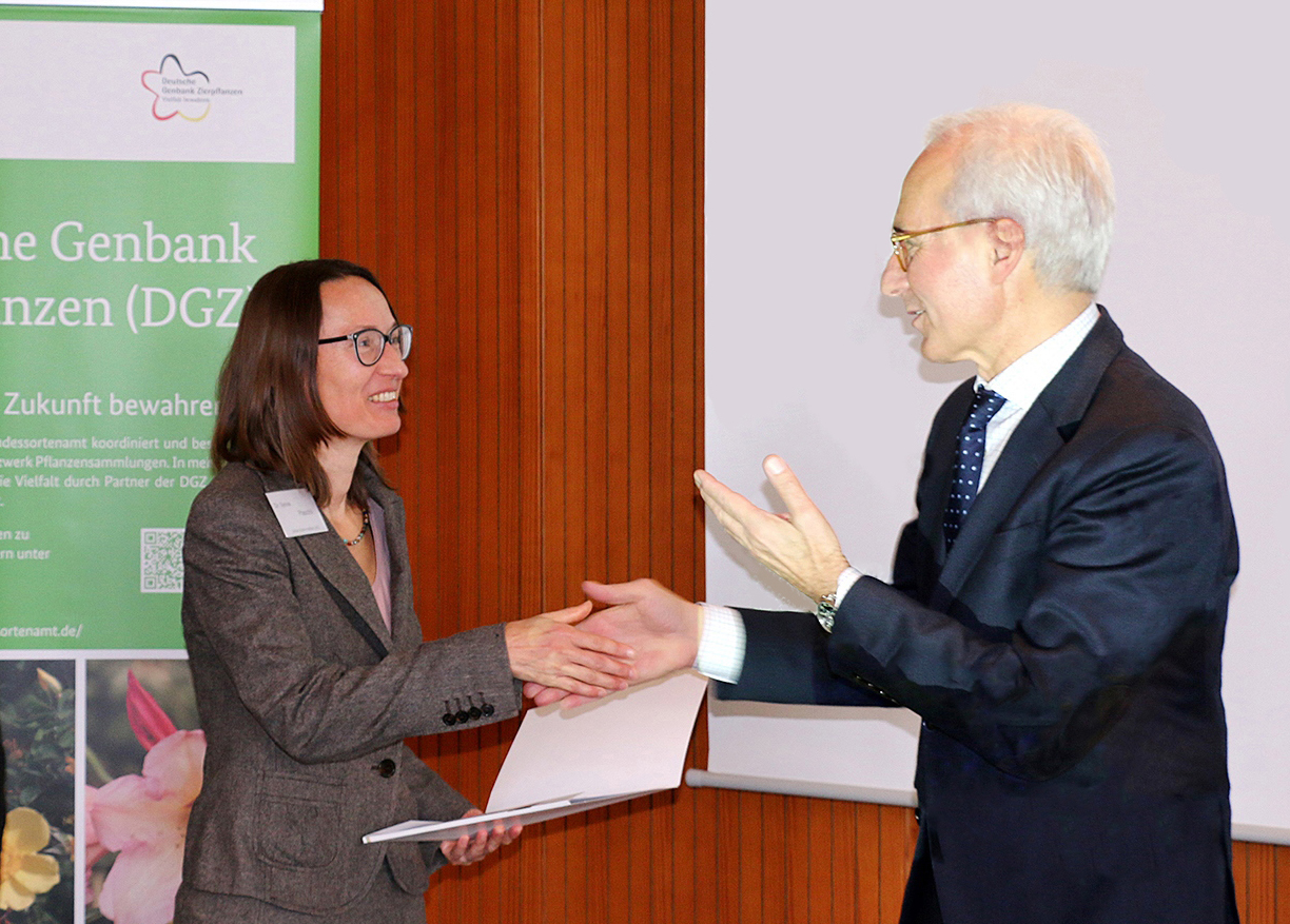 Dr. Sylvia Plaschil (JKI) erhält vom Präsidenten des Bundessortenamts, Udo von Kröcher, Partnerschaftsurkunde der Deutschen Genbank Zierpflanzen (© Maryse Huve/Bundessortenamt)