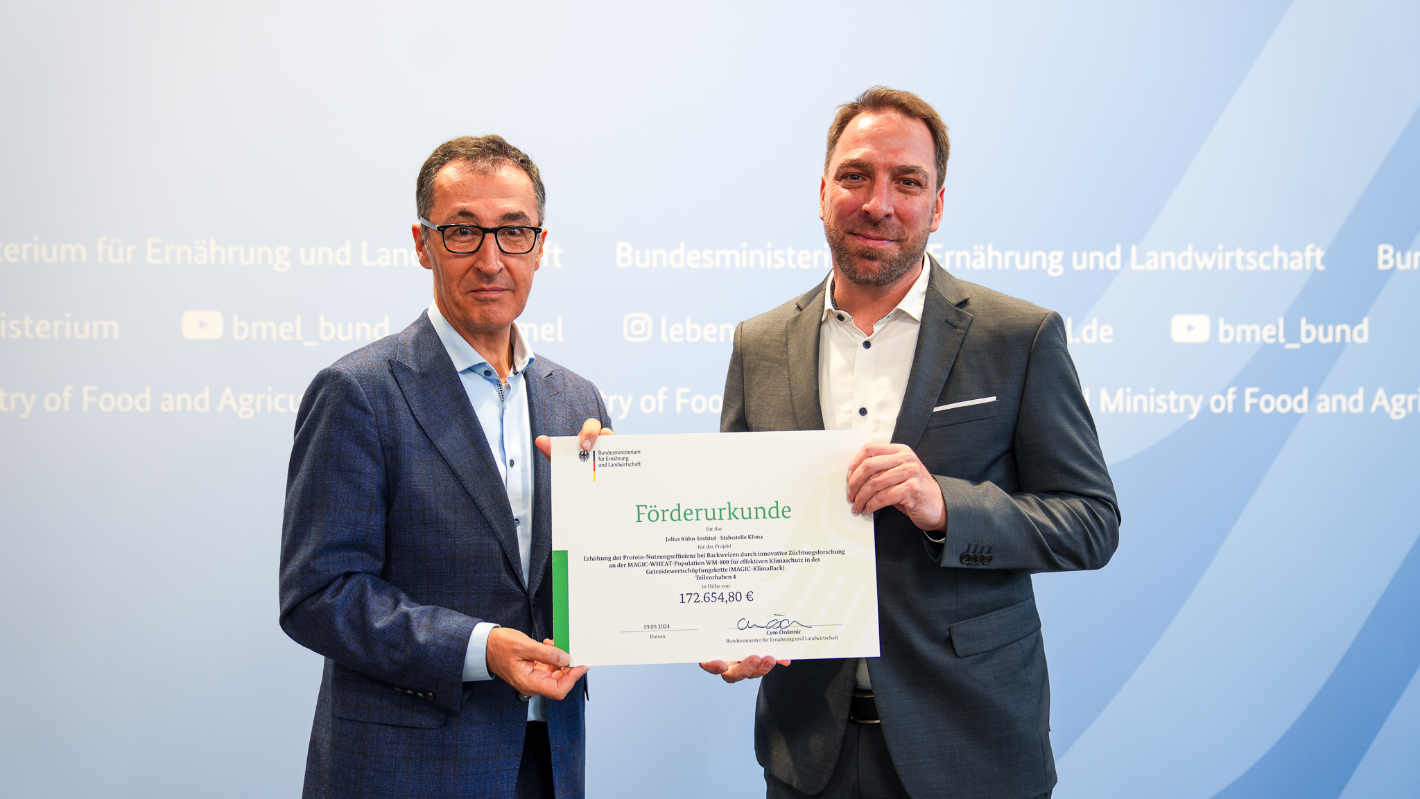 Bundeslandwirtschaftsminister Cem Özdemir (links) überreicht am 19.9.2024 Dr. Til Feike vom Julius Kühn-Institut den Förderbescheid zum Verbundprojekt MagicKlimaback.