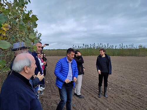 Dr. Lukas Beule (r.) erläutert der Klimaanpassungs-Expertengruppe  aus dem Westbalkan die Versuchsanstellung zum Agroforstsystem im Praxiskooperationsbetrieb Alt Madlitz.