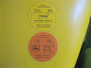 Two round labels stating date and workshop of the inspection