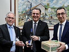 Als Gastgeschenk für den Landwirtschaftsminister Brasiliens Carlos Favaro (Mitte) überreichte Cem Özdemir (r.) einen PIWI-Wein der JKI-Rebenzüchtung. Links: JKI-Präsident Ordon.