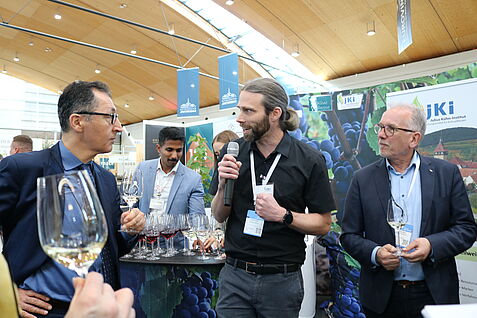 Am Messesonntag, den 09. März, besuchte Bundeslandwirtschaftsminister Cem Özdemir den JKI-Stand auf der Fachmese EUROVINO und war bald darauf im angeregten Gespräch mit Dr. Oliver Trapp, Leiter des JKI-Instituts für Rebenzüchtung am Geilweilerhof in Siebeldingen, und JKI-Präsident Prof. Dr. Frank Ordon vertieft. Im Hintergrund richtet Dr. Nagarjun Malagol die Gläser für die nächsten Gäste an. ©Julia Fuchs/JKI