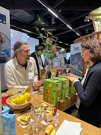 Dr. Janne Lempe, Züchtungsforscherin vom JKI in Pillnitz erklärt das Zuchtprogramm für resistente Rebsorten und schenkt dabei sortenreinen Apfelsaft an einen Besucher aus. © S. Barnert/JKI