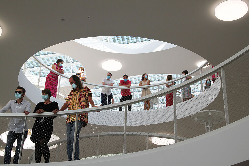 
	Blick nach oben: Mitarbeitende des Institutes für Pflazenschutz im Obst- und Weinbau verfolgen das Geschehen im Atrium aus den oberen Etagen. © Leefken/JKI
