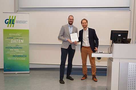 Dr. Ralph Stoop übergibt den Preis an Herrn Branding