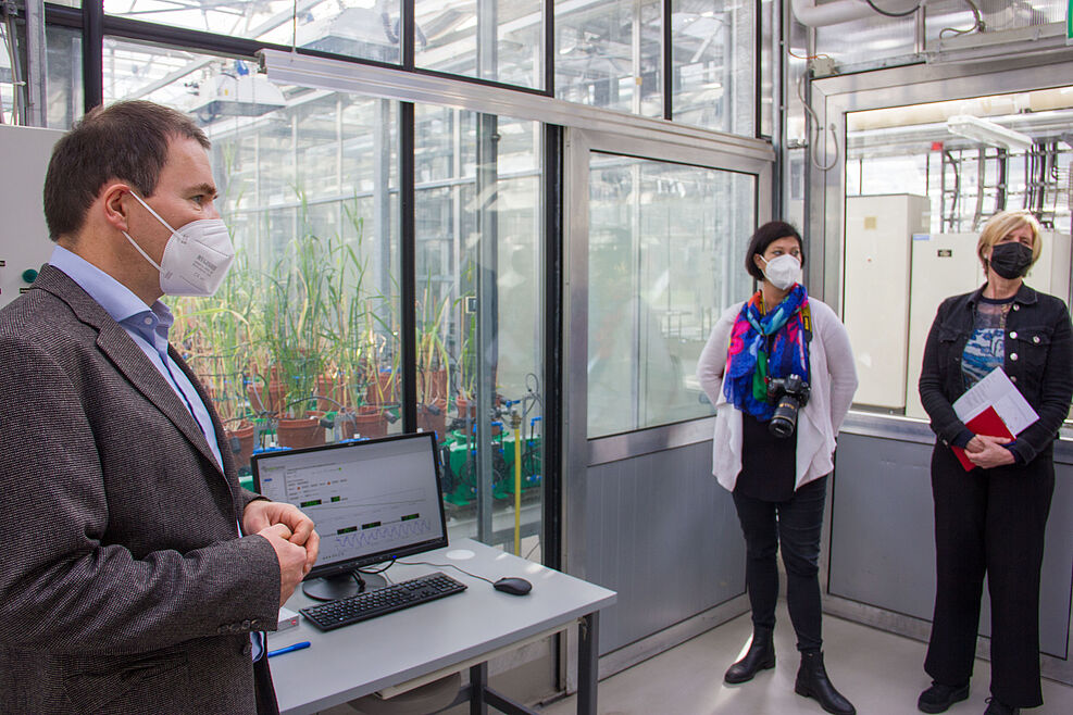 
	Dr. Albrecht Serfling (links) vom JKI-Institut für Resistenzforschung und Stresstoleranz erklärt Besuchern des Crop Trusts das "Plantarray" im Gewächshaus. ©J. Kaufmann/JKI
