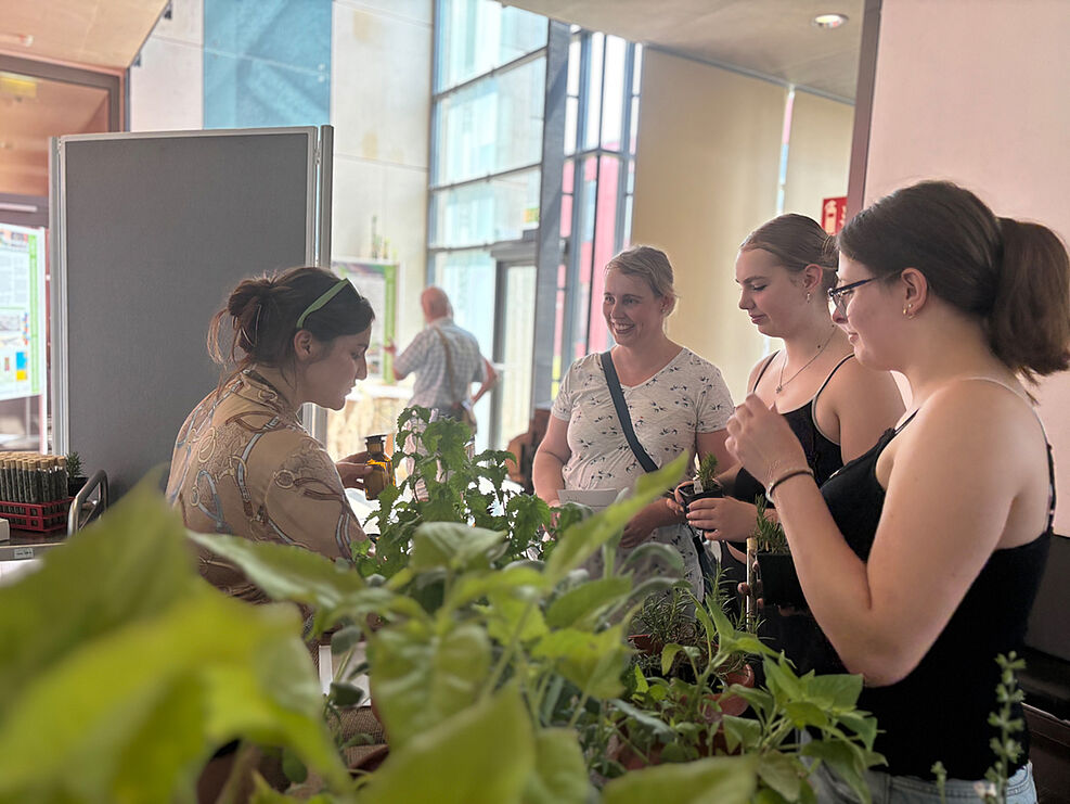 
	Natalie Vogelgsang (JKI-Institut für die Sicherheit biotechnologischer Verfahren bei Pflanzen) mit Besucherinnen an der Duftorgel-Station. © Sarah Barnert
