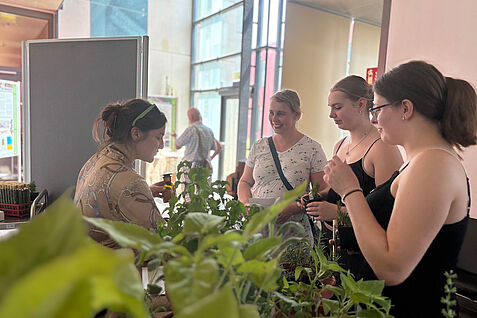 Natalie Vogelgsang (JKI-Institut für die Sicherheit biotechnologischer Verfahren bei Pflanzen) mit Besucherinnen an der Duftorgel-Station. © Sarah Barnert