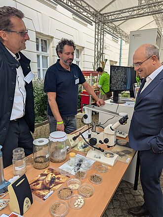 BMLEH-Staatssekretär Prof. Dr. Dr. Markus Schick  am JKI-Stand bei Dr. Cornel Adler und Dr. Benjamin Fürstenau. (Foto: Isabel Haberkorn/JKI)