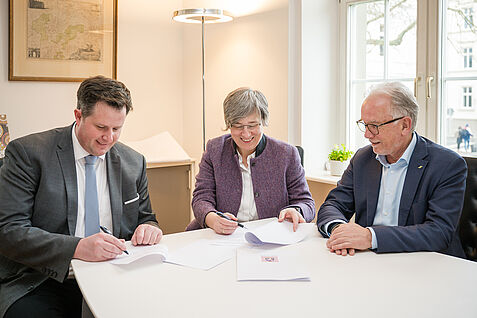 Dr. Andreas Stahl (l.) unterzeichnet am 31.03.26 seinen Dienstvertrag für die Berufung auf die Professur für Resistenz und Toleranz von Kulturpflanzen an der Justus-Liebig-Universität Gießen (JLU) mit  JLU-Präsidentin Prof. Dr. Katharina Lorenz (Mitte) und JKI-Präsident Prof. Dr. Frank Ordon (r.) © JLU/Katrina Friese