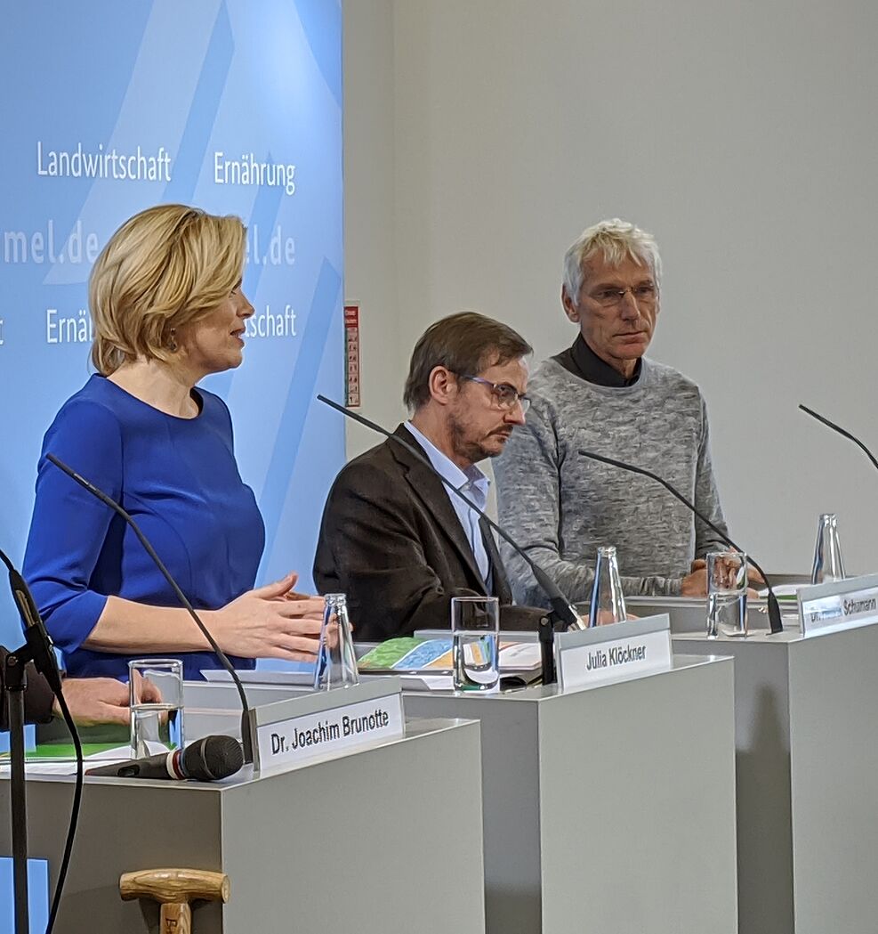 
	Ministerin Klöckner, Prof. Greef sowie weiterer Mann stehen an Rednerpulten
