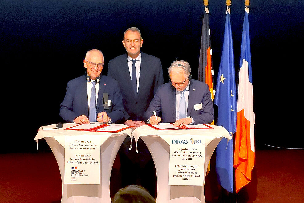 Prof. Dr. Christian Huyghe (links), Wissenschaftlicher Direktor der INRAe und JKI-Präsident Prof. Dr. Frank Ordon (rechts) beim Signieren der Kooperationsvereinbarung in der französischen Botschaft in Berlin. Im Hintergrund der Botschaftsgesandte Emmanuel Cohet.