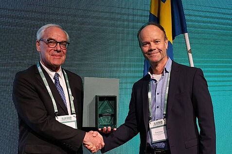 IUFRO President John Parrotta presented the award to Henrik Hartmann (on the right).