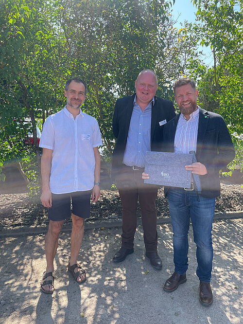 Der Bürgermeister von Sanitz Enrico Bendlin eröffnete den Tag der offenen Türen 2025 der Einrichtungen am Forschungscampus Groß Lüsewitz. Hier posiert er mit Gastgeschenk mit Benjamin Stick (JKI-ZL) und Fabian Strauß (NORIKA GmbH) © S. Barnert/JKI